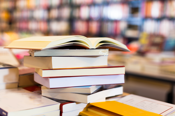 A stack of books and other stationery on a table.