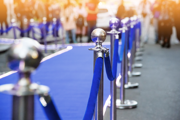 Blue carpet with rope and stations at an event.