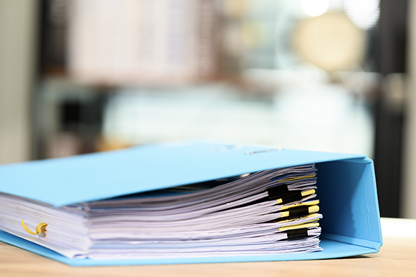 A blue binder positioned on a desktop or tabletop